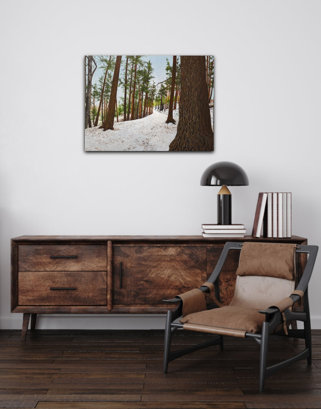 Wooden sideboard with a chair and decorative items against a white wall with a forest painting.