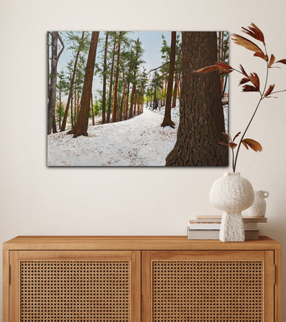 Framed forest scene above a wooden cabinet with decorative items.