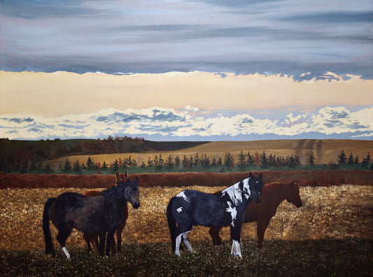 Horses standing in a field with a scenic background of trees and clouds.